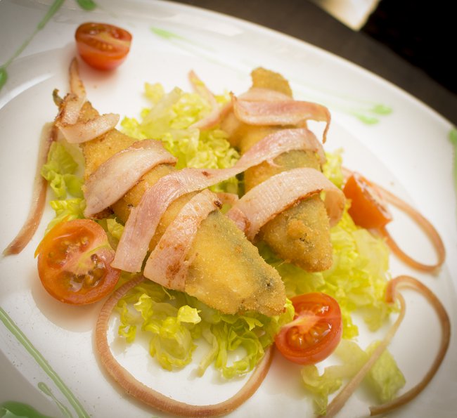 Boquerones rellenos con Philadelphia y mermelada de frambuesa, envueltos en bacon preparado por El Piyayo , Taberna